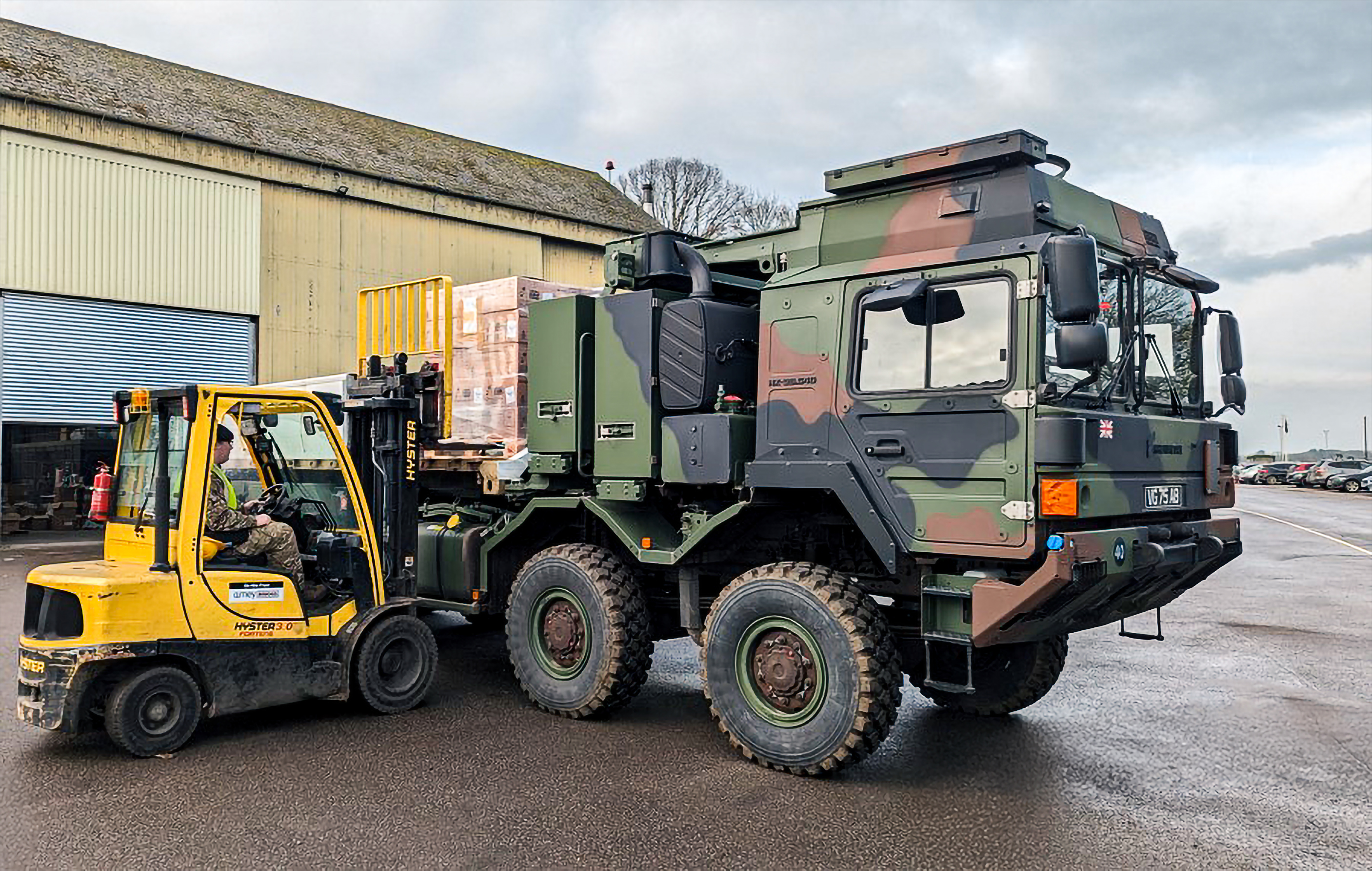 A forklift loads supplies onto a military enhanced pallet loading system.