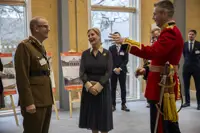 Her Royal Highness, The Duchess of Edinburgh, laughs with soldiers wearing ceremonial uniforms.