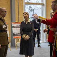 Her Royal Highness, The Duchess of Edinburgh, laughs with soldiers wearing ceremonial uniforms.