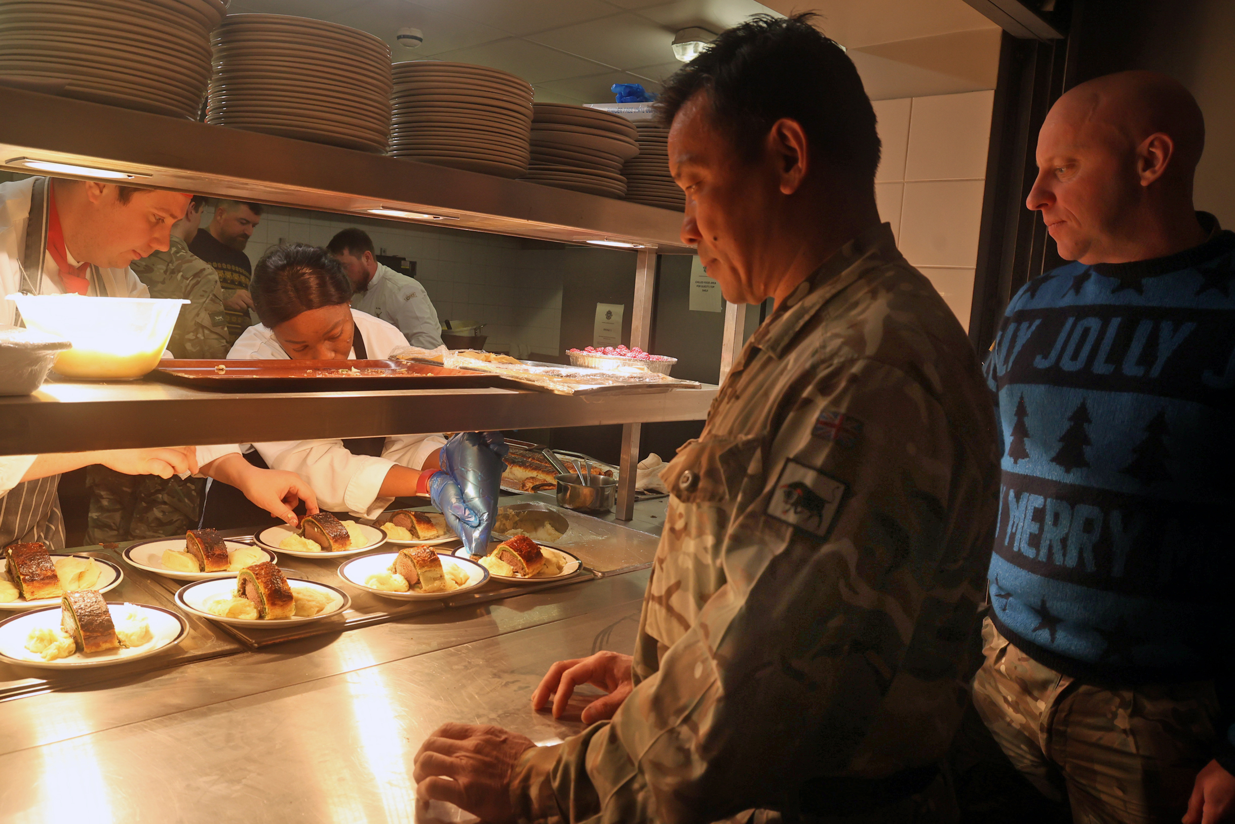 Soldiers prepare to receive food from a kitchen.