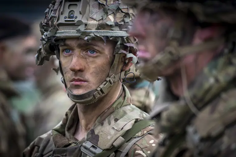 close up portrait of a soldiers wearing camouflage uniform and helmet.