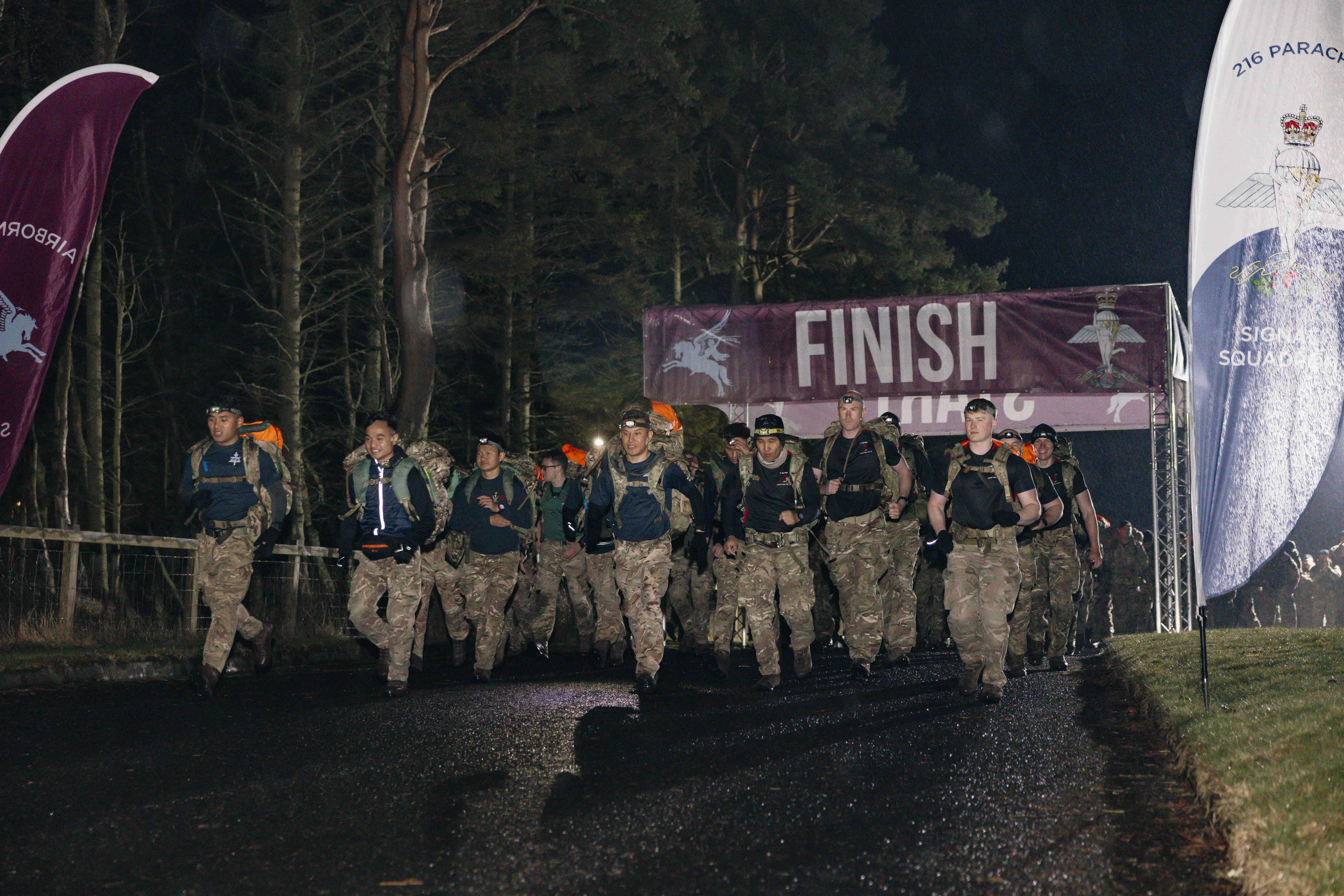 Soldiers shown crossing the start line in the Lanyard Trophy Competition in the wet weather and dark skies early in the morning.