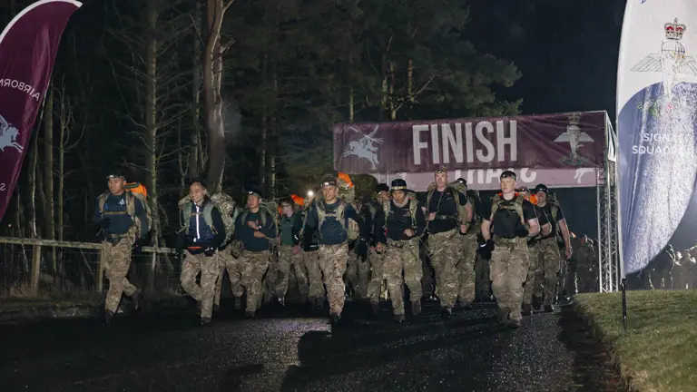 Soldiers shown crossing the start line in the Lanyard Trophy Competition in the wet weather and dark skies early in the morning.