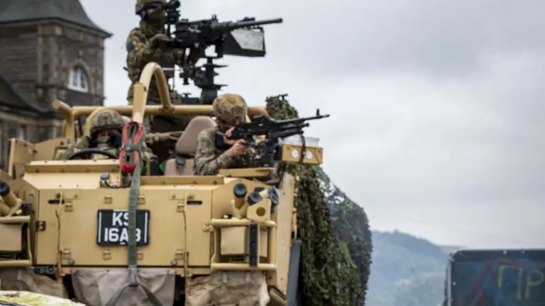 Soldiers shown demonstrate an attack scenario outside with debris including a child's swing, a car and white goods and a jackal with Soldiers in coming through the back.