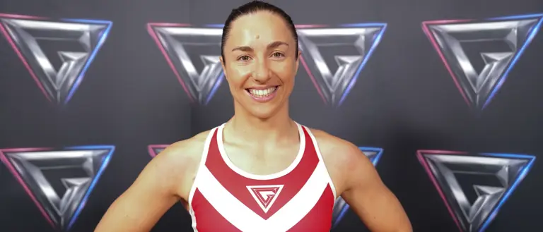 Athletic woman in a red and white sports bra posing confidently against a backdrop with repeating geometric logos.