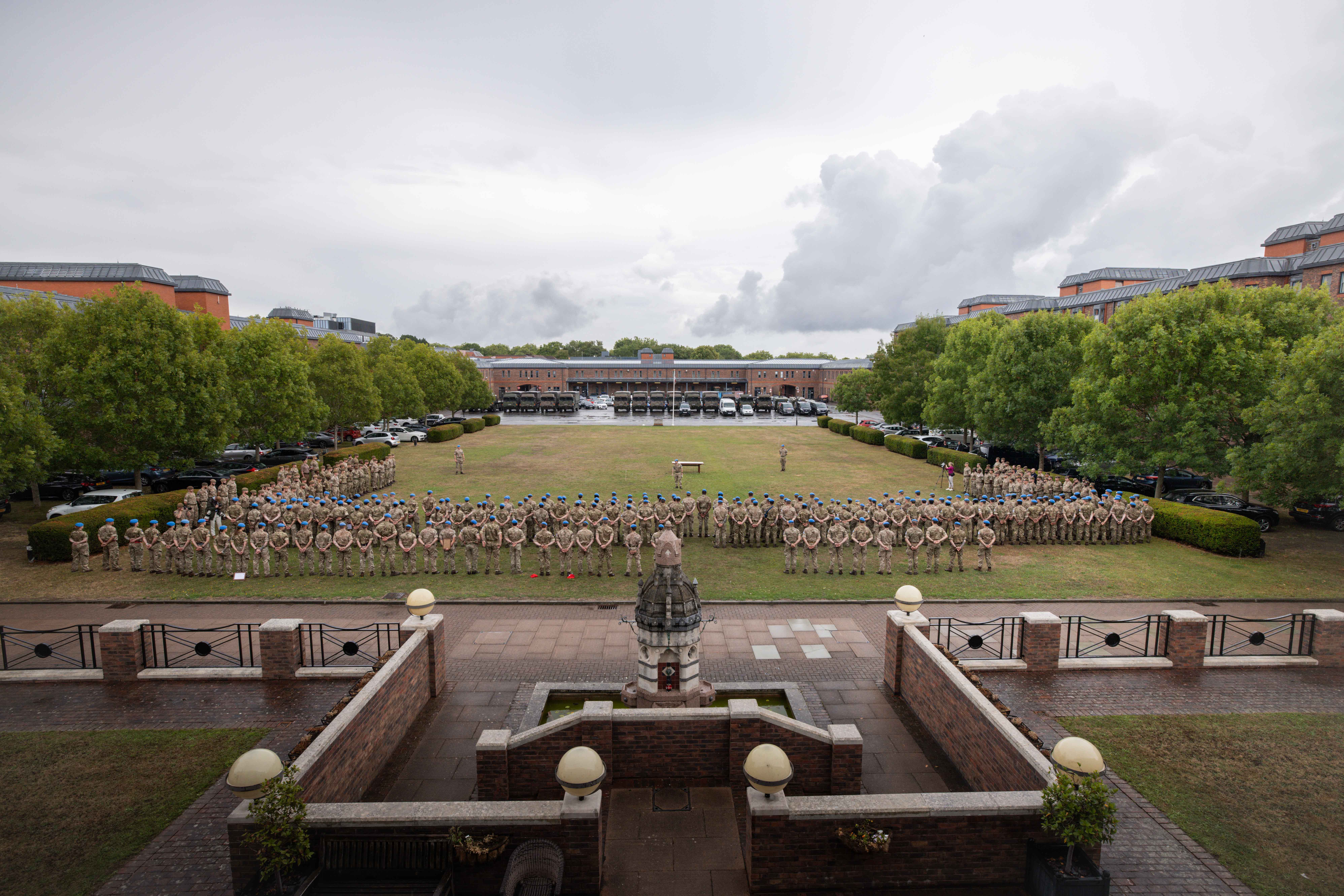 Soldiers in camouflage uniforms stand on a parade.